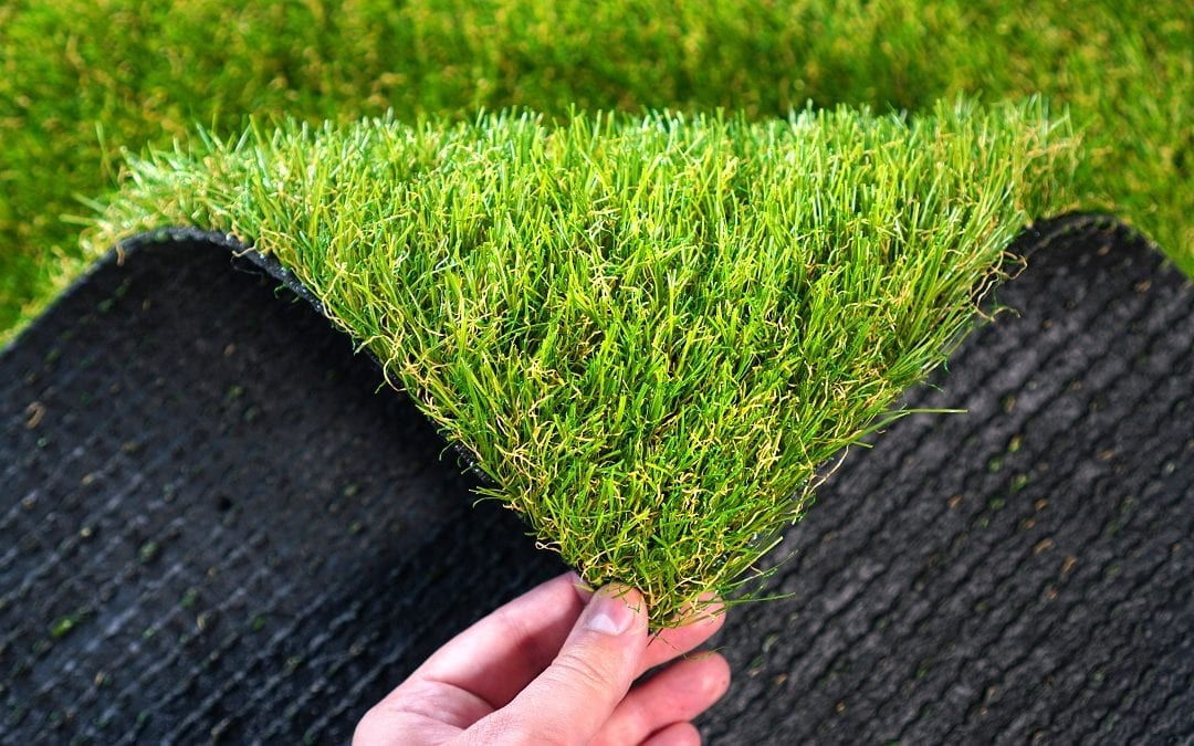 Hand holding an artificial grass roll. Greenering with an artificial turf.
